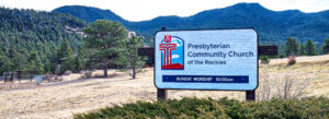 photo of sign with mountains in the background